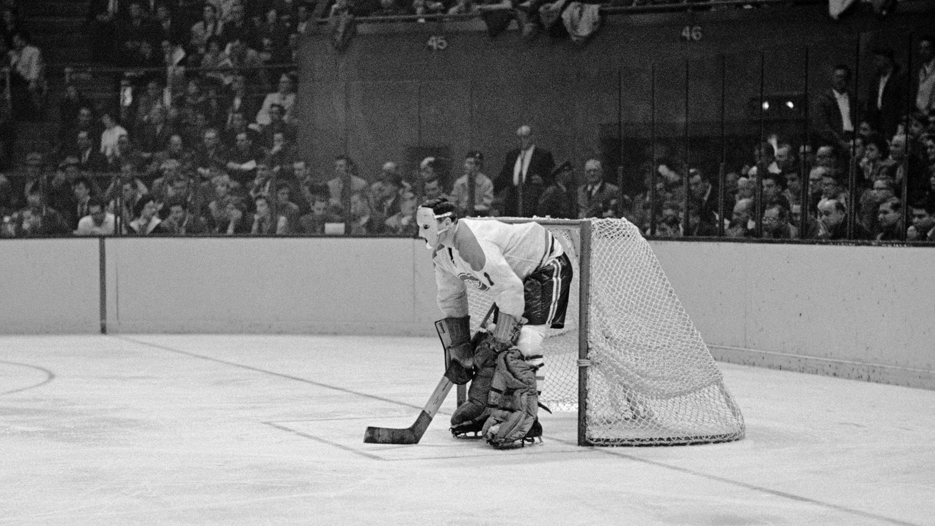 Jacques Plante, Star-Torwart der Montreal Canadiens mit einer Schutzmaske auf der Eisfläche vor dem Tor. Jacques Plante, Star-Torwart der Montreal Canadiens mit einer Schutzmaske auf der Eisfläche vor dem Tor.