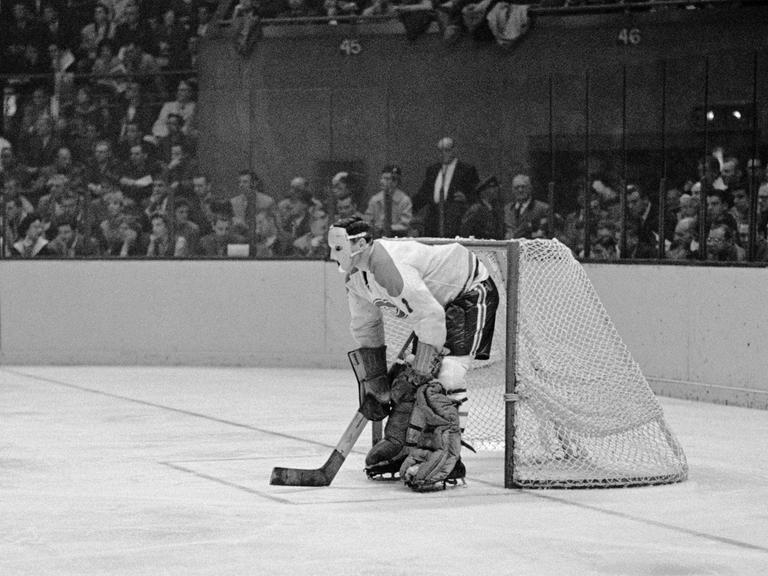 Jacques Plante, Star-Torwart der Montreal Canadiens mit einer Schutzmaske auf der Eisfläche vor dem Tor.