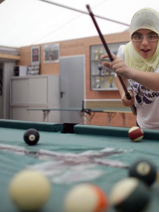 Aleyna spielt am Samstag (03.10.2009) in der provisorischen Zeltmoschee in Köln Billard. Die muslimischen Gemeinden in Deutschland haben am Samstag wieder ihre Moscheen für einen Einblick in ihr Gemeindeleben geöffnet.