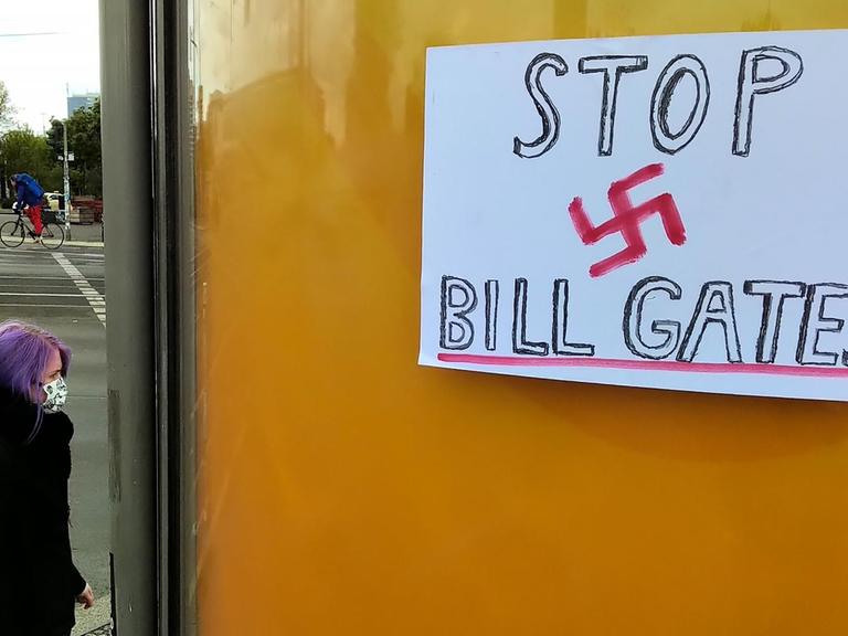 "Stop Bill Gates" mit einem roten Hakenkreuz steht auf einem Plakat an einer Bushaltestelle in Berlin, 3. Mai 2020.
