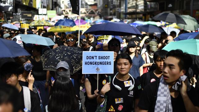 Demonstranten am 21.7. in Hongkong. Eine Person trägt ein Schild, auf dem "Erschießt keine Hongkonger" steht.