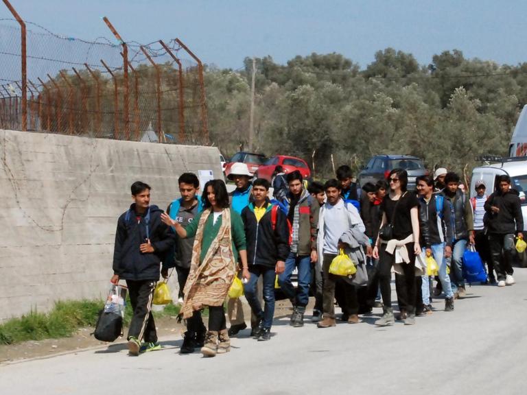 Flüchtlinge gehen an der Mauer des Auffanglagers "Moria" auf der griechischen Insel Lesbos in der Hafenstadt Mitilini entlang.