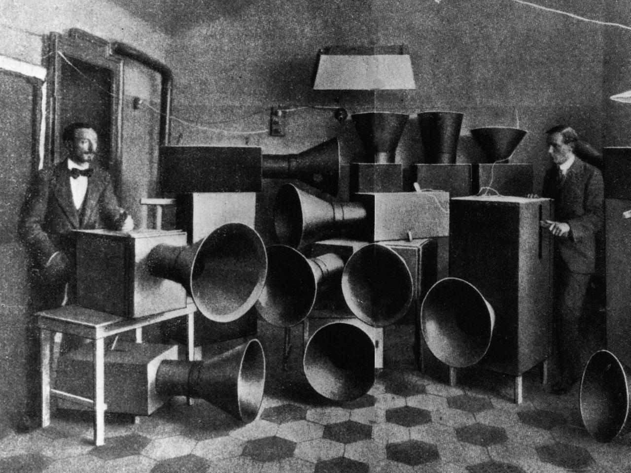 Luigi Russolo und sein Assistent Piatti mit den Intonarumori-Geräuschmaschinen 1914. Das Intonarumori oder "Instrument zur Erzeugung von Geräuschen" wurde 1913 vom futuristischen Komponisten Luigi Russolo (1885 1947) entwickelt. 
