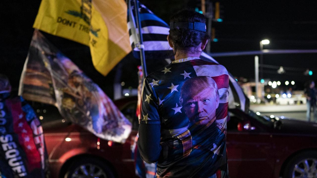 Nachdem er positiv auf COVID-19 getestet worden war, versammelten sich Unterstützer des US-Präsidenten Donald Trump mit Flaggen und seinem Konterfei auf einem T-Shirt vor dem Walter Reed National Military Medical Center in Bethesda, Maryland. Nachdem er positiv auf COVID-19 getestet worden war, versammelten sich Unterstützer des US-Präsidenten Donald Trump mit Flaggen und seinem Konterfei auf einem T-Shirt vor dem Walter Reed National Military Medical Center in Bethesda, Maryland.