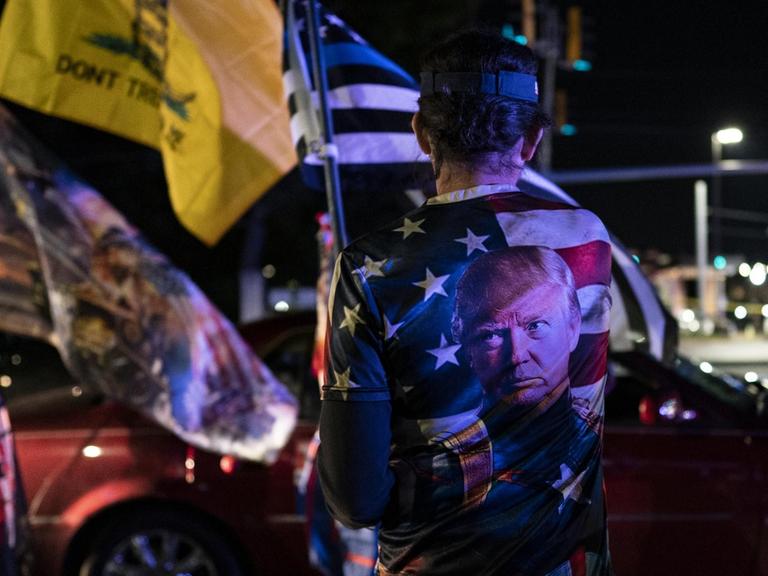 Nachdem er positiv auf COVID-19 getestet worden war, versammelten sich Unterstützer des US-Präsidenten Donald Trump mit Flaggen und seinem Konterfei auf einem T-Shirt vor dem Walter Reed National Military Medical Center in Bethesda, Maryland.