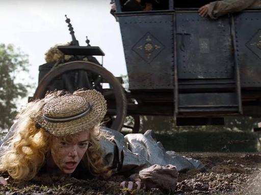 Filmszene "The Favourite" vom Regisseur Yorgos Lanthimos: Queen Anne (Emma Stone) liegt im Dreck auf dem Boden vor einer Kutsche