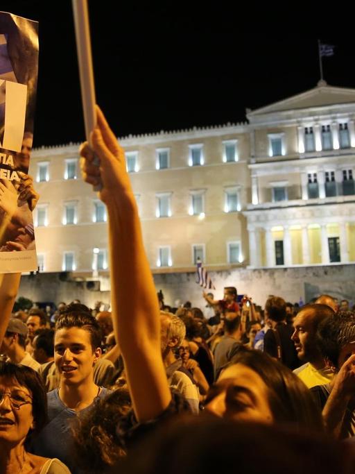 Demonstranten stehen mit griechischen Fahnen und "Oxi"-Plakaten vor dem angestrahlten Parlament in Athen.