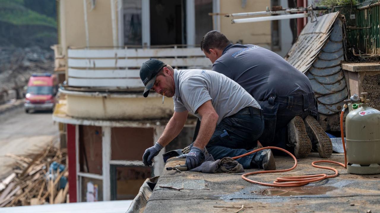 Dachdecker arbeiten an einem der Häuser, die von der Flutkatastrophe beschädigt worden sind. Dachdecker arbeiten an einem der Häuser, die von der Flutkatastrophe beschädigt worden sind.