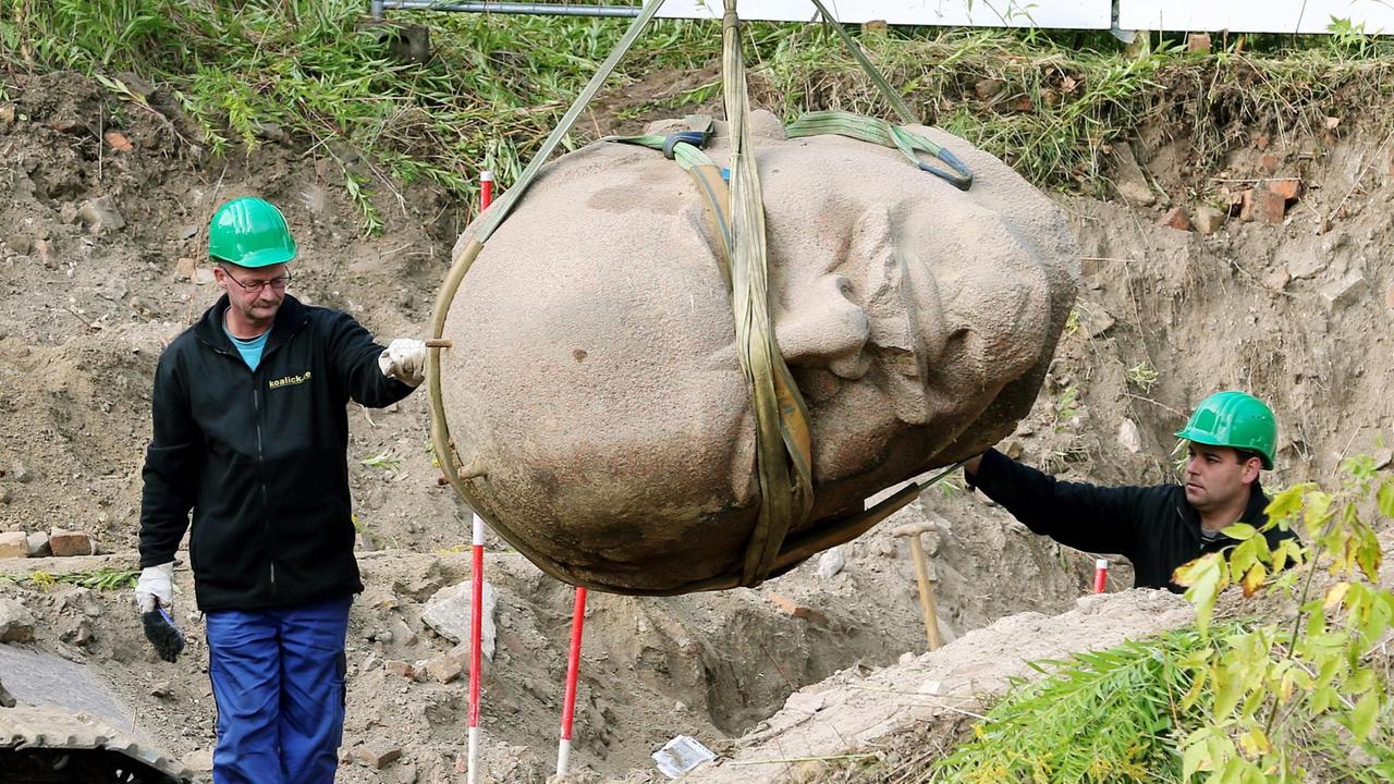 Arbeiter einer Spezialfirma sichern in einem Waldstück am Müggelsee in Berlin den an einem Kran hängenden Kopf einer Lenin-Statue. Arbeiter einer Spezialfirma sichern in einem Waldstück am Müggelsee in Berlin den an einem Kran hängenden Kopf einer Lenin-Statue.