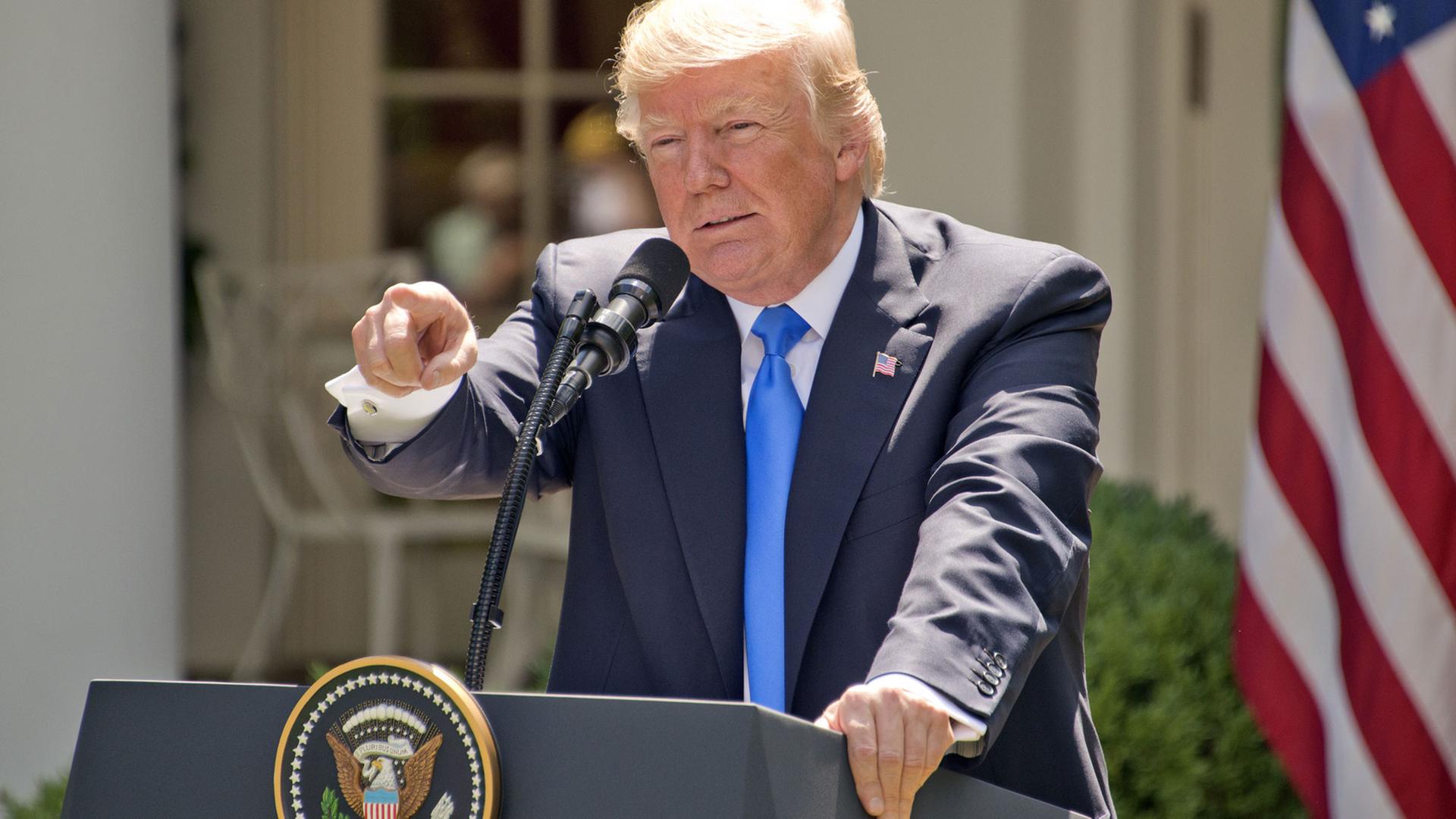 US-Präsident Donald Trump mit einer Schraubzange in der Hand.