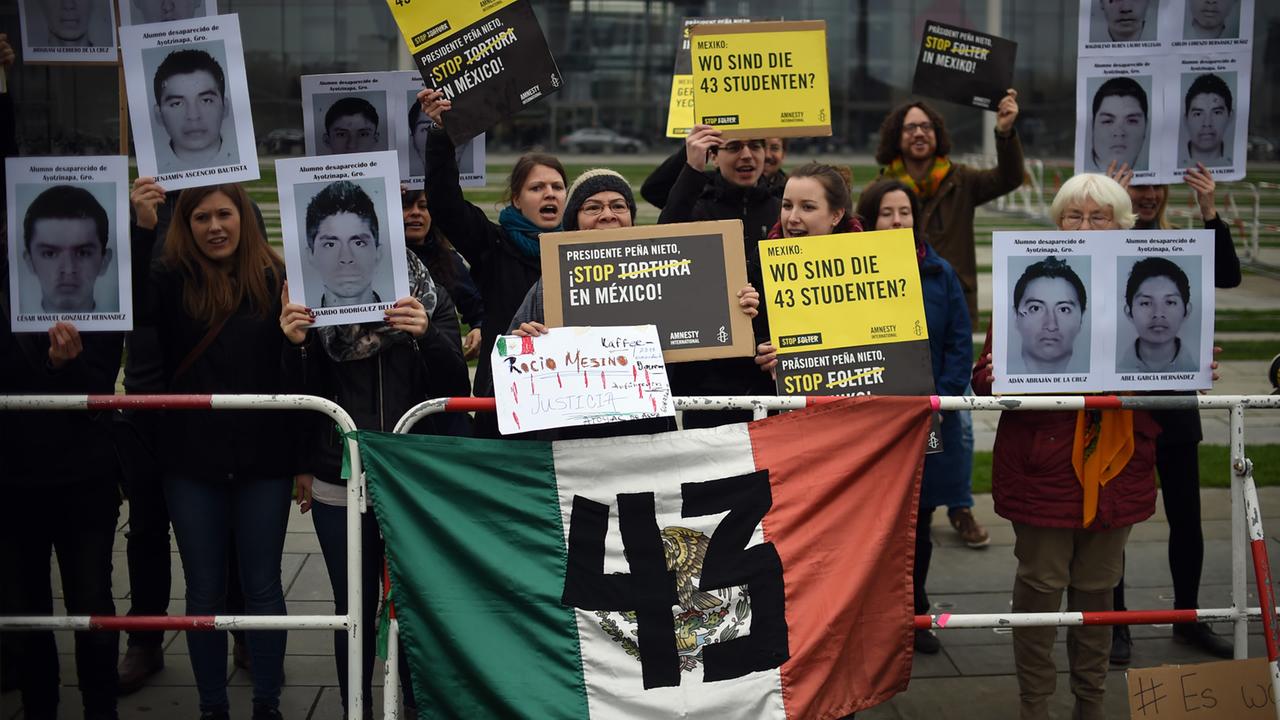Mitglieder von Amnesty International protestieren in Berlin gegen Folter und zeigen Bilder von 43 verschwundenen Studenten. Mitglieder von Amnesty International protestieren in Berlin gegen Folter und zeigen Bilder von 43 verschwundenen Studenten.