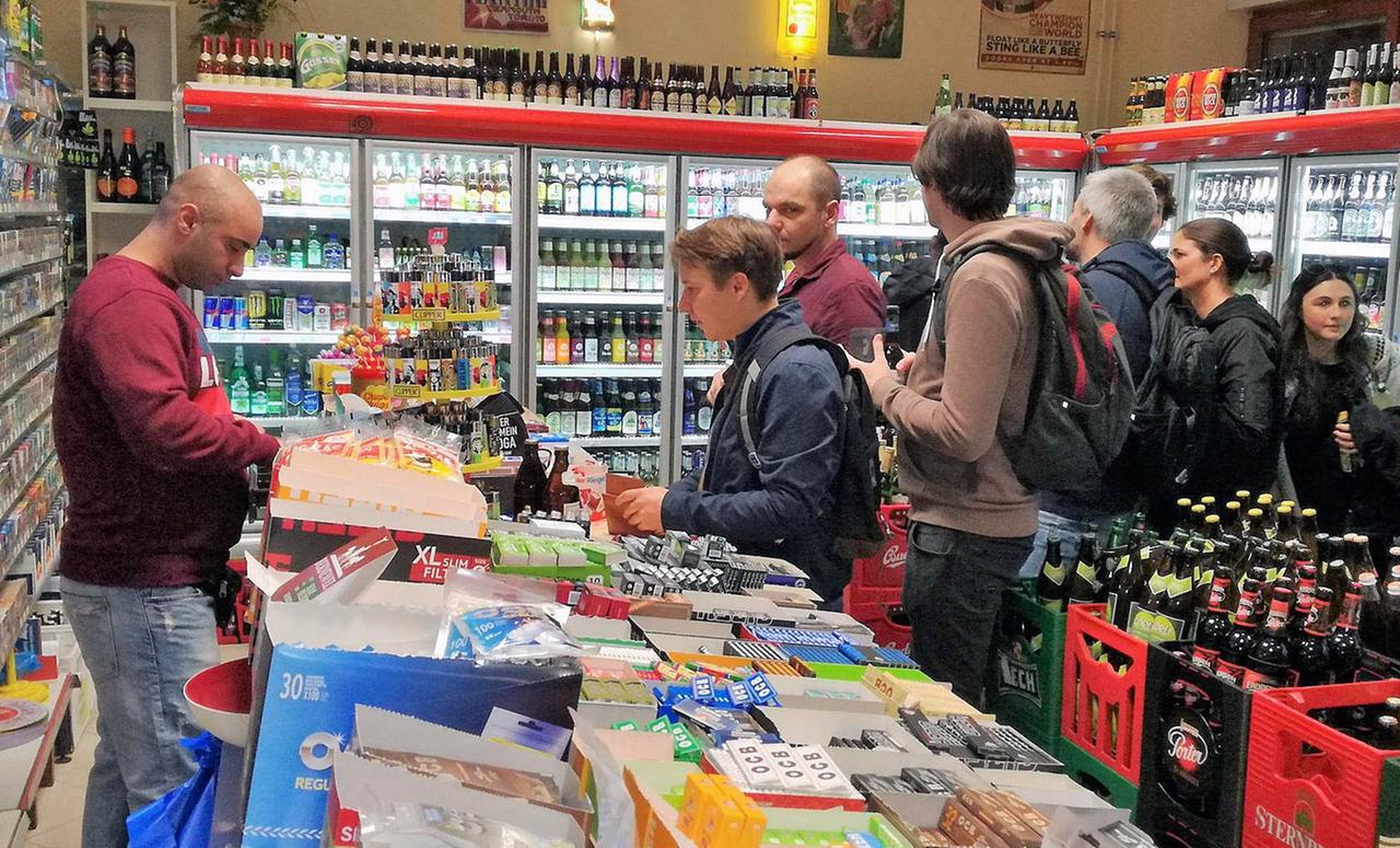 Betreiber hinter dem Tresen in seinem Späti und viele Kunden Betreiber hinter dem Tresen in seinem Späti und viele Kunden