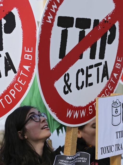 Demonstranten mit Schildern, auf denen die Wörter TTIP und CETA durchgestrichen sind