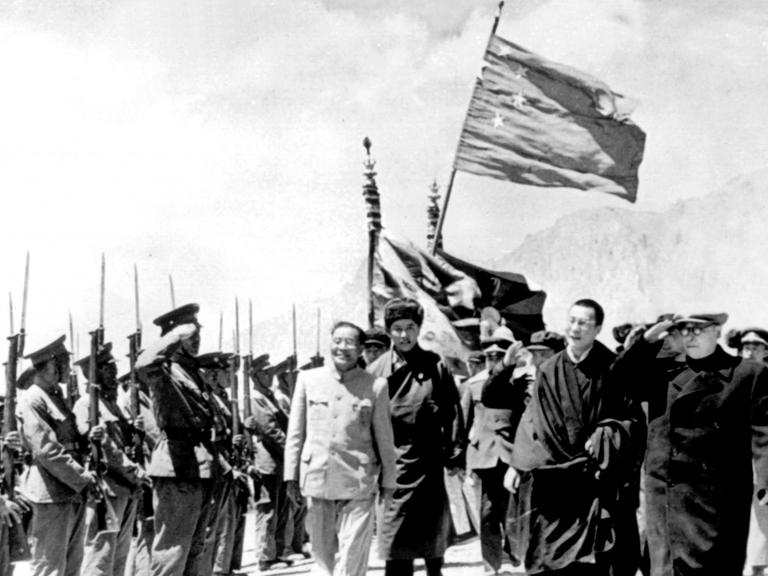 Mai 1965: Der Leiter der chinesischen Delegation, der stellvertretende Ministerpräsident Chen Yi (2.v.r.), schreitet mit dem Dalai Lama zu seiner Rechten und dem Pantschen Lama zu seiner Linken eine tibetanische Ehrengarde ab, nachdem Tibet zur Autonomen Region erklärt wurde.