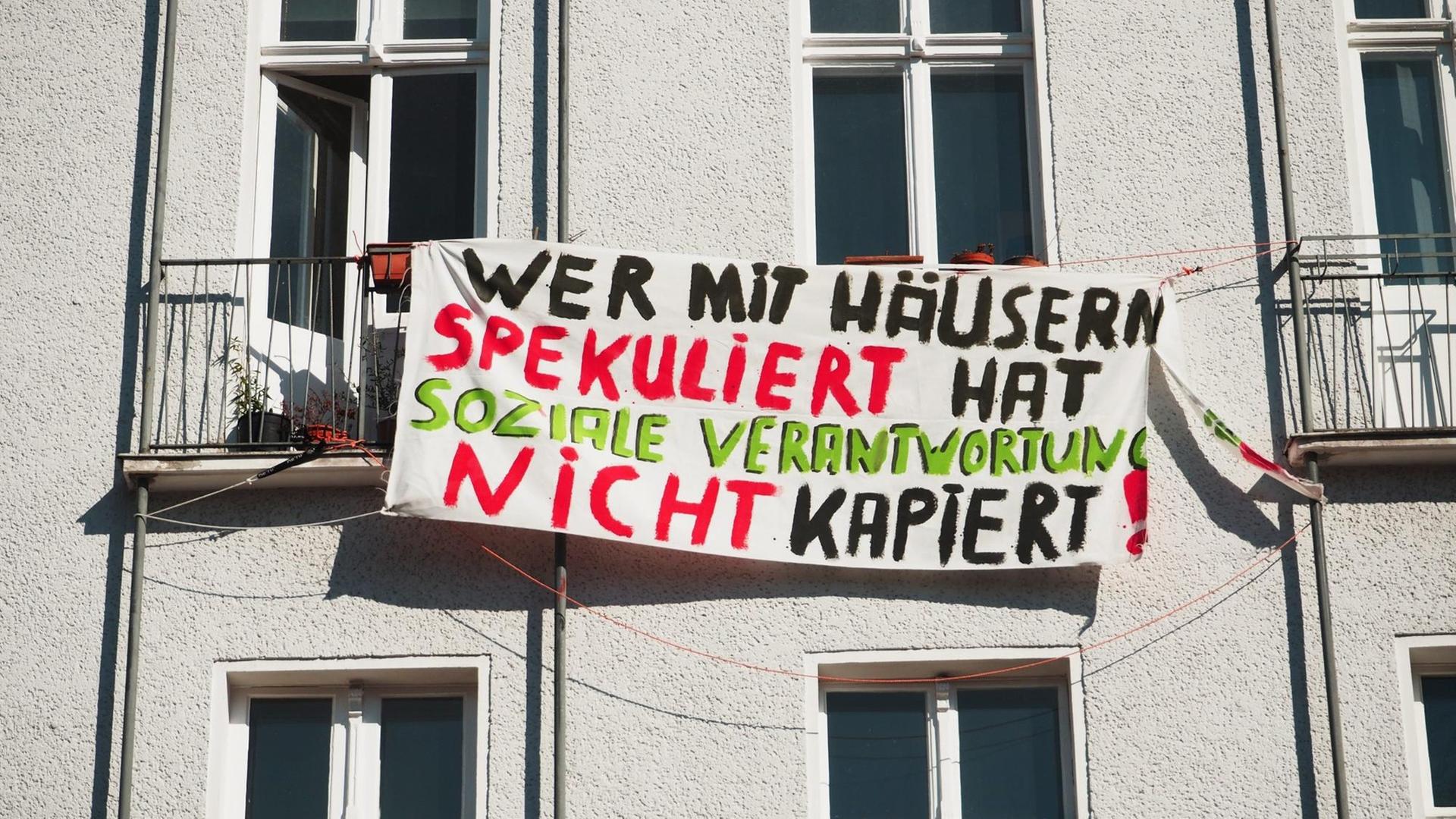 Wer mit Häusern spekuliert hat soziale Verantwortung nicht kapiert!" steht auf einem Transparent an einer Hausfassade in Berlin im Bezirk Schöneberg am 19.03.2015. Foto: Wolfram Steinberg/dpa. Wer mit Häusern spekuliert hat soziale Verantwortung nicht kapiert!" steht auf einem Transparent an einer Hausfassade in Berlin im Bezirk Schöneberg am 19.03.2015. Foto: Wolfram Steinberg/dpa.