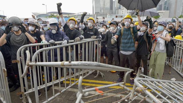Gegner eines Gesetzes, das die Auslieferung von strafrechtlichen Verdächtigen an das chinesische Festland ermöglichen würde, versammeln sich vor dem Parlamentsgebäude in Honkong.