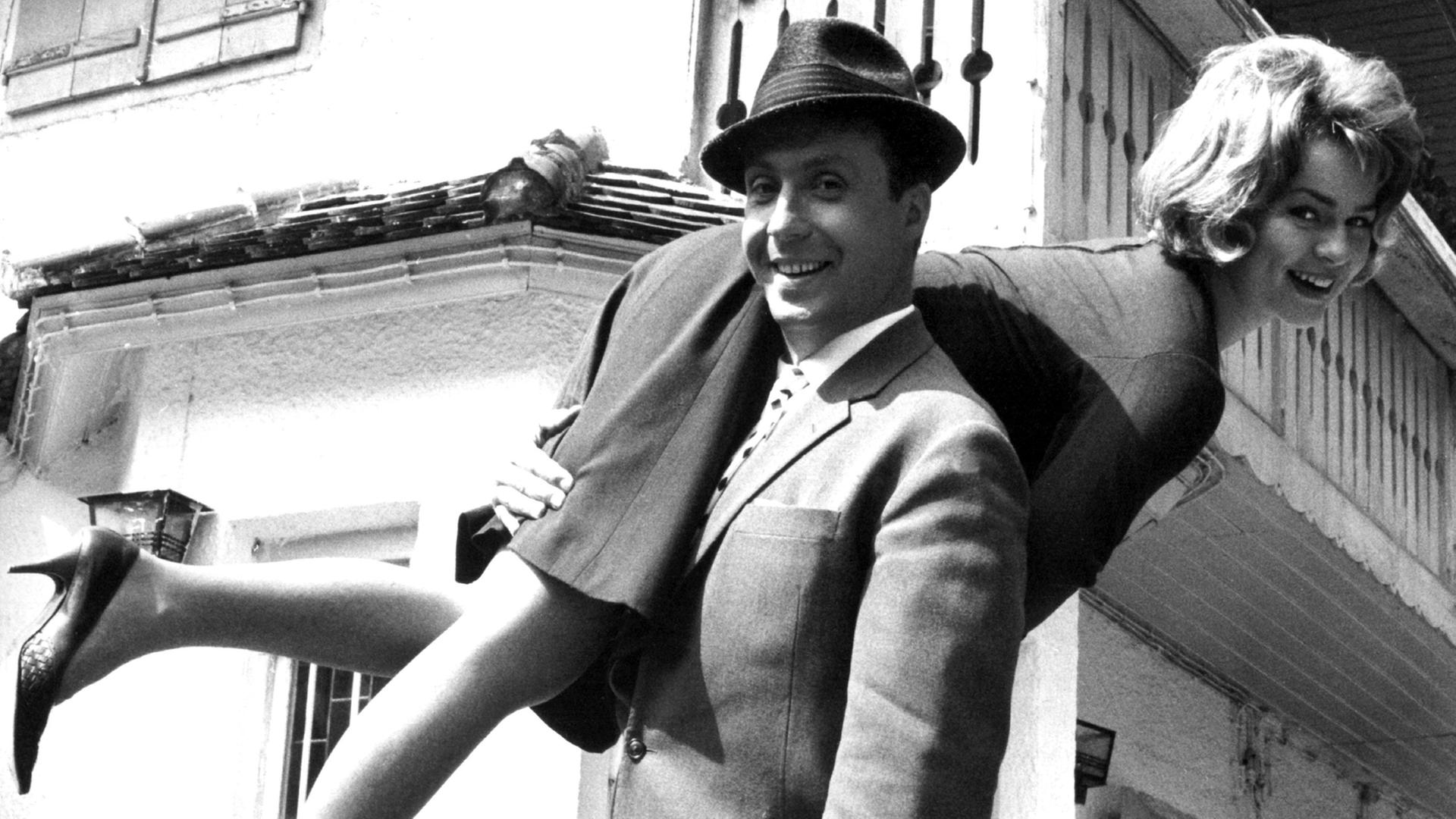 Der Schauspieler, Entertainer und Sänger Peter Alexander "schultert" als Valentien Haase in dem Film "Hilfe - Meine Braut klaut" von 1964 seine Braut (Conny Froboess). Der Österreicher, der eigentlich Peter Alexander Neumayer heißt, wurde am 30.6.1926 in Wien gebore