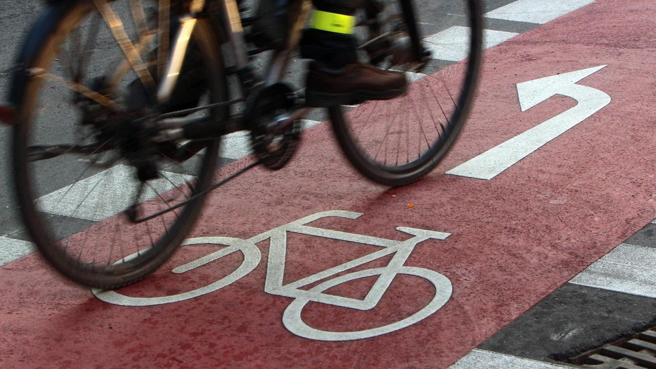 Ein Radfahrer befährt einen farblich abgesetzten Radweg auf der Kaiserstraße in der Innenstadt von Karlsruhe. Ein Radfahrer befährt einen farblich abgesetzten Radweg auf der Kaiserstraße in der Innenstadt von Karlsruhe.