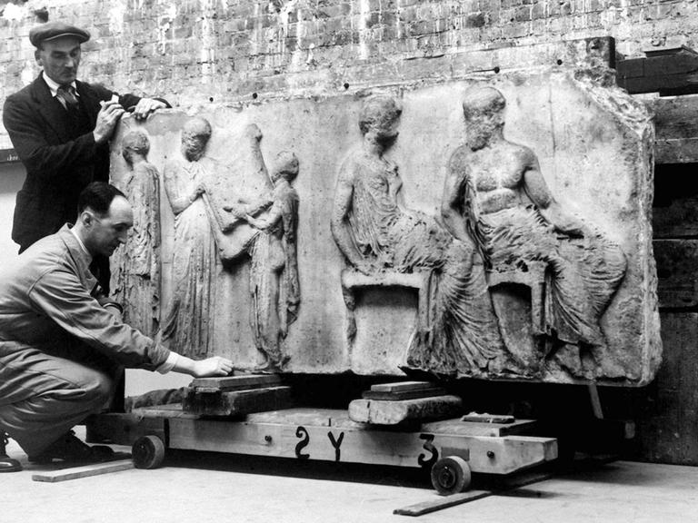 Zwei Lastträger transportieren am 27. November 1948 das kostbare Elgin-Marmorrelief, das während des Zweiten Weltkrieges aus Sicherheitsgründen in einem unterirdischen Tunnel aufbewahrt wurde. Das rund 2500 Jahre Kunstwerk stammt aus Griechenland und ist im Britischen Museum in London zu sehen.