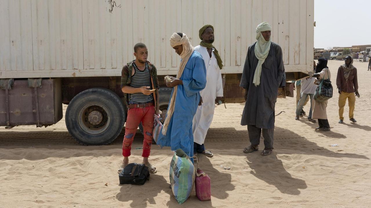Migranten bezahlen um die Grenze im Norden des Niger zu Algerien überschreiten zu können. Migranten bezahlen um die Grenze im Norden des Niger zu Algerien überschreiten zu können.