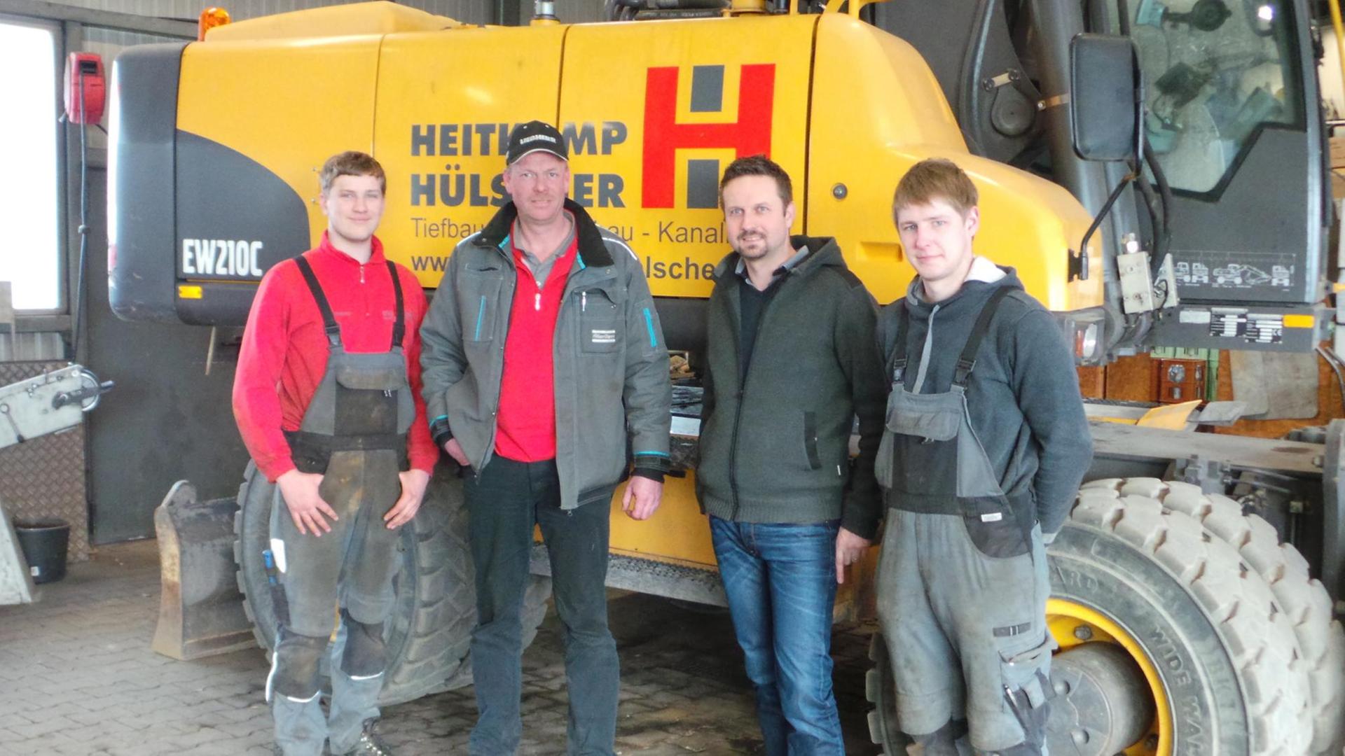 Mitarbeiter des Bauunternehmens Heitkamp & Hülscher stehen vor einem Bagger. Sie sind an dem Unternehmen beteiligt. Mitarbeiter des Bauunternehmens Heitkamp & Hülscher stehen vor einem Bagger. Sie sind an dem Unternehmen beteiligt.