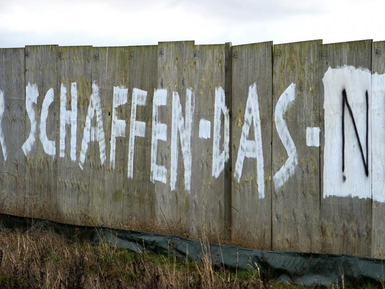 Der Schriftzug "Wir schaffen das nie" steht an einem Bauzaun der neuen Bundesstraße B96 bei Rambin (Mecklenburg-Vorpommern) auf der Insel Rügen, die zum Wahlkreis von Bundeskanzlerin Merkel gehört.