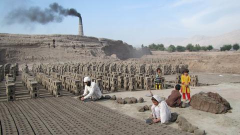 Erwachsene und Kinder arbeiten in einer Ziegelfabrik im Oktober 2014 in der afghanischen Provinz Nangarhar.