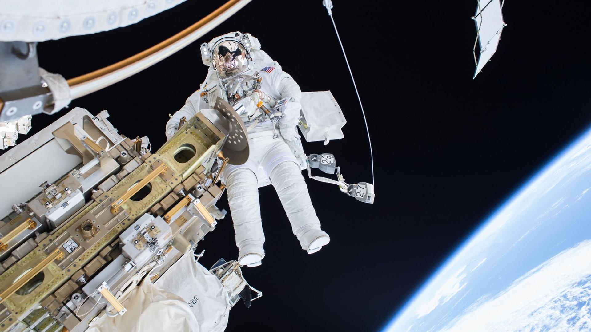 Nur durch Leinen gesichert: Ein ISS-Astronaut beim Außeneinsatz