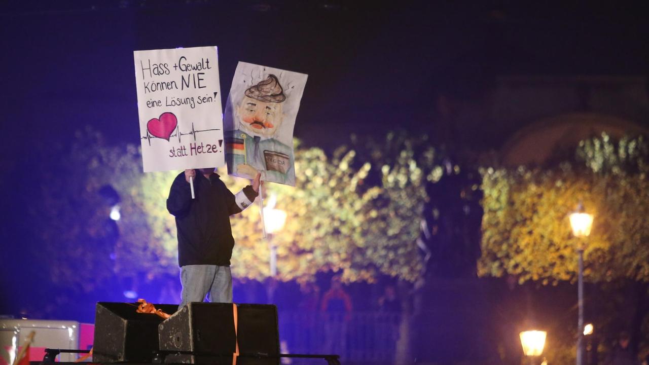 Der Teilnehmer einer Demonstration gegen Pegida hält am 19.10.2015 in Dresden (Sachsen) ein Plakat mit der Aufschrift «Herz statt Hetze».