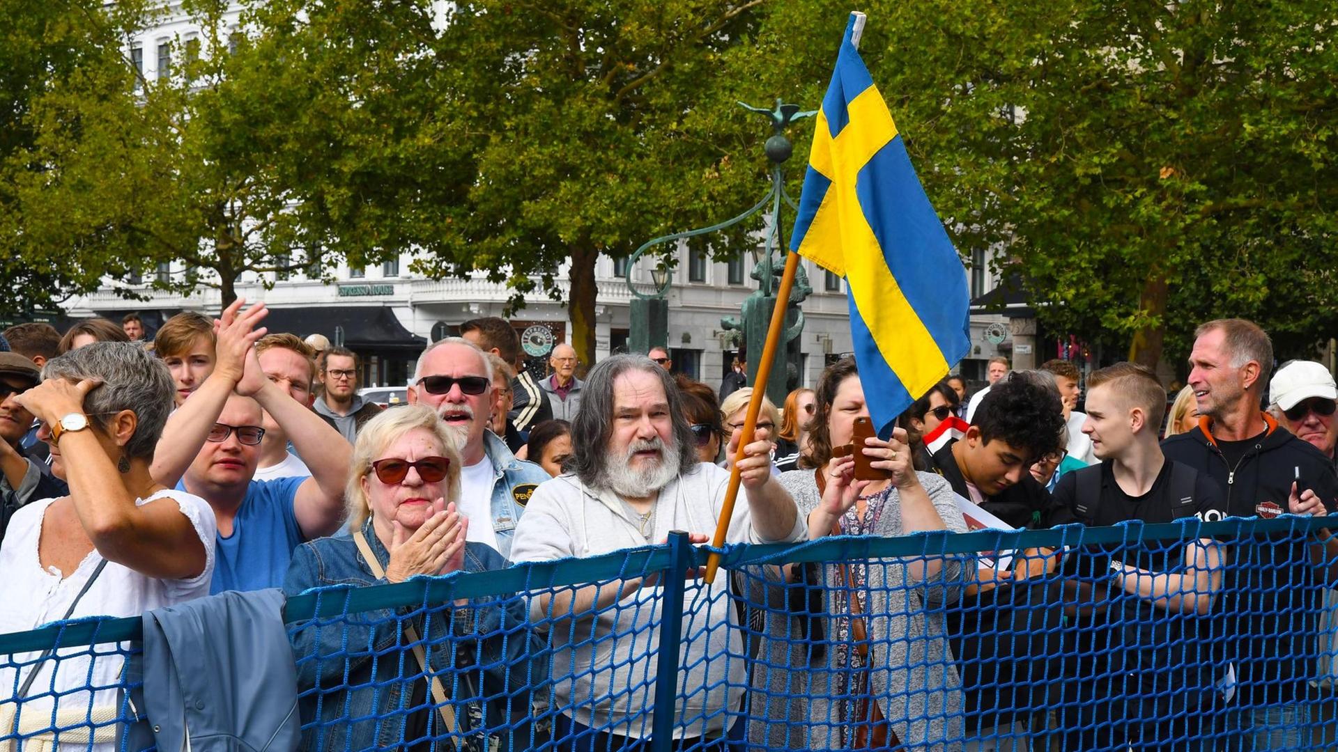 Zuschauer bei einer Veranstaltung der rechtspopulistischen Schweden Demokraten (SD) in Malmö. Ein Mann mit langen grauen Haaren und Bart hält eine schwedische Flagge hoch.. Zuschauer bei einer Veranstaltung der rechtspopulistischen Schweden Demokraten (SD) in Malmö. Ein Mann mit langen grauen Haaren und Bart hält eine schwedische Flagge hoch..