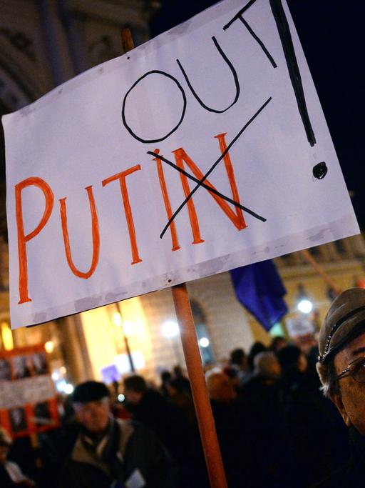 Ein Demonstrant in Budapest hält ein Schild mit der Aufschrift "Putin Out"