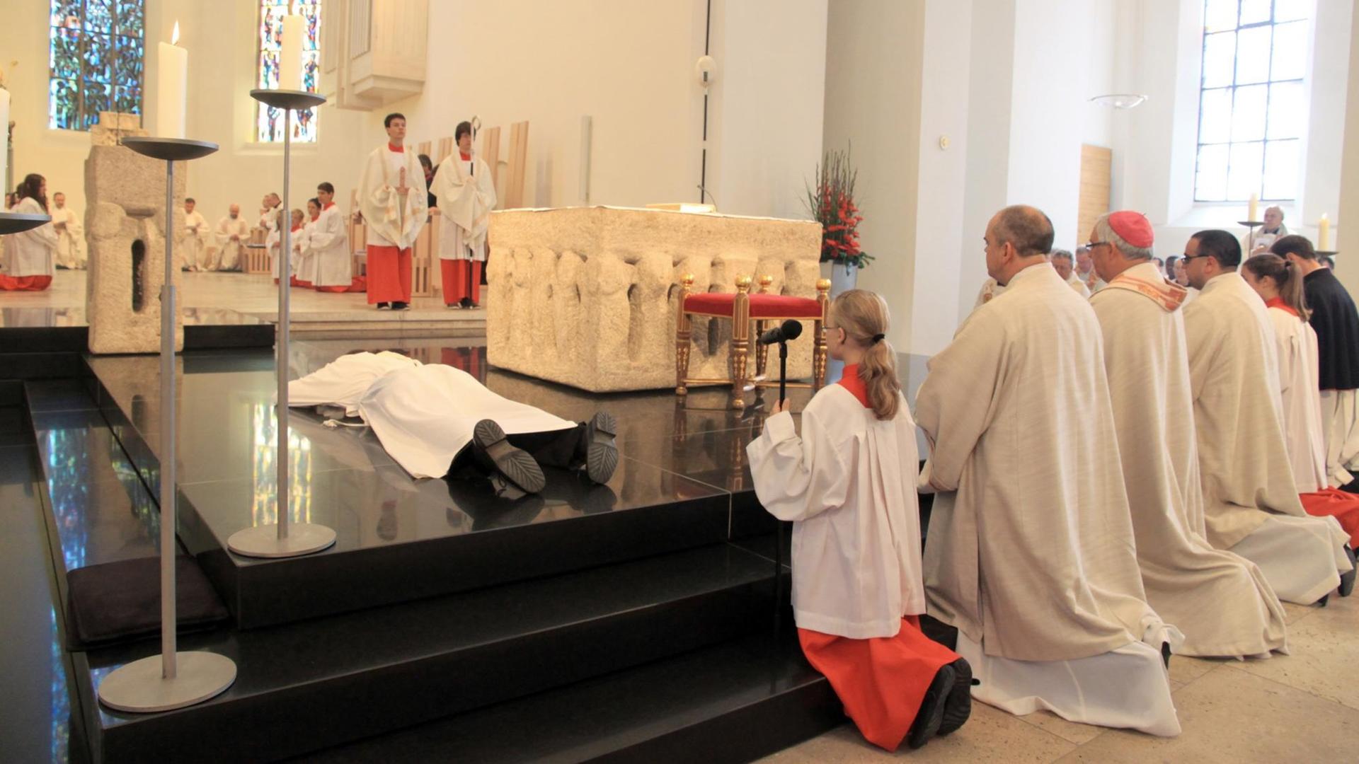 Kilian Krug (l) liegt bei seiner Priesterweihe am Samstag (07.07.2012) flach vor dem Altar im Dom von Rottenburg (Kreis Tübingen). Krug ist ein Symbol für den Priestermangel in der katholischen Kirche geworden. Zum ersten Mal in der Geschichte des Bistums Rottenburg-Stuttgart wurde mit ihm in diesem Jahr nur ein einziger Priester geweiht. Kilian Krug (l) liegt bei seiner Priesterweihe am Samstag (07.07.2012) flach vor dem Altar im Dom von Rottenburg (Kreis Tübingen). Krug ist ein Symbol für den Priestermangel in der katholischen Kirche geworden. Zum ersten Mal in der Geschichte des Bistums Rottenburg-Stuttgart wurde mit ihm in diesem Jahr nur ein einziger Priester geweiht.