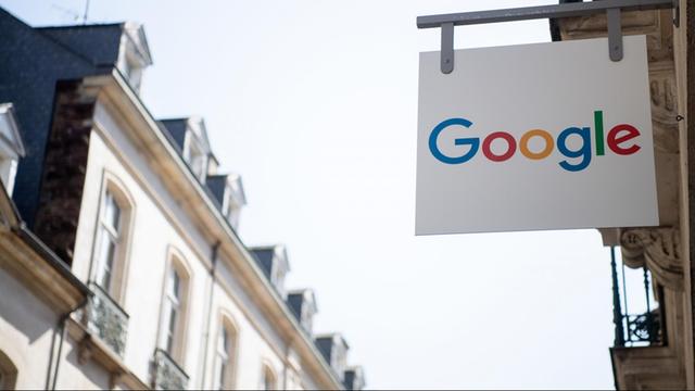 Ein Schild mit der Aufschrift "Google" hängt an einem Haus.