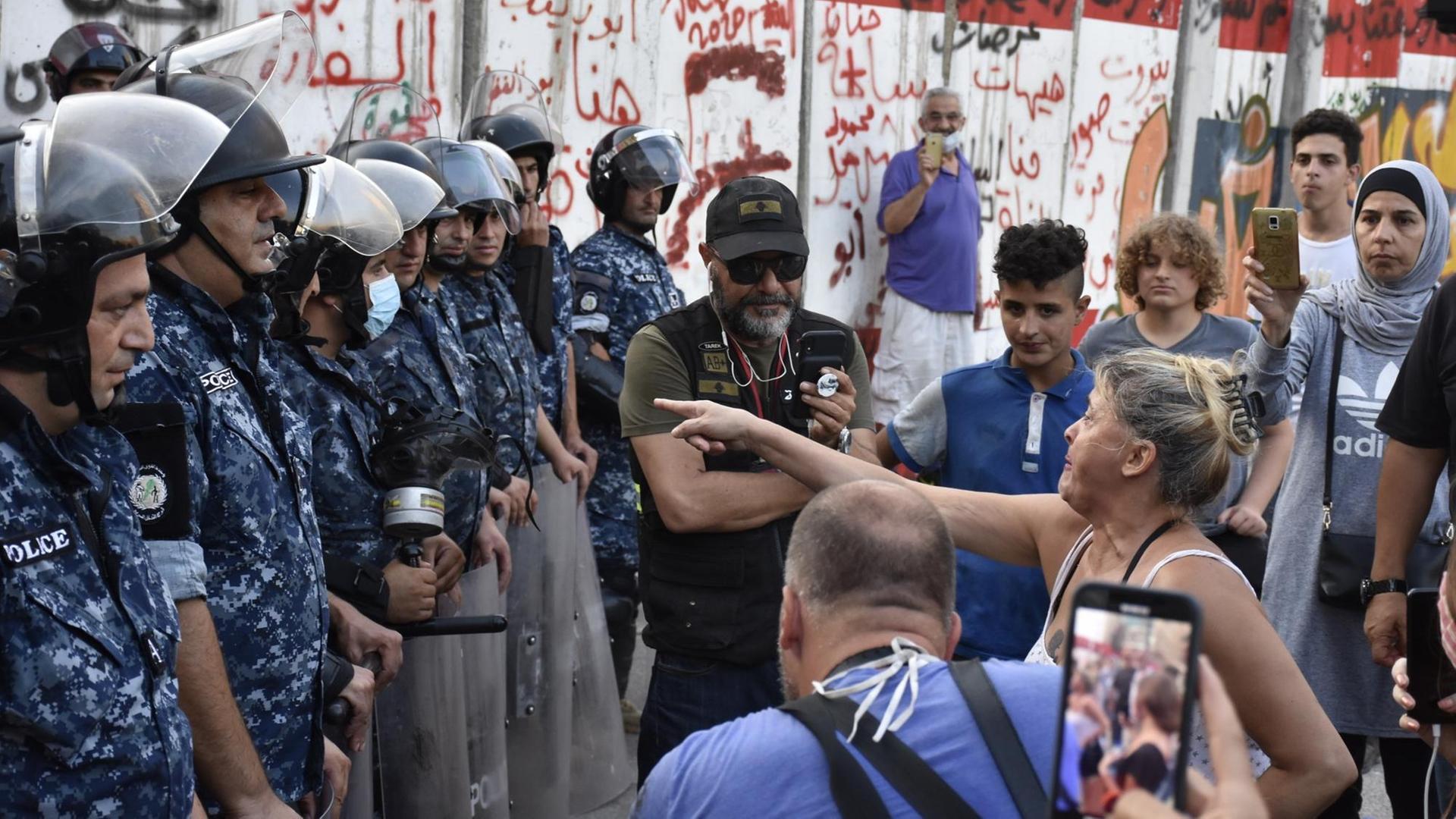 Libanesische Sicherheitskräfte und protestierende Bürgerinnen und Bürger stehen sich Anfang Juli 2020 in Beirut gegenüber. Libanesische Sicherheitskräfte und protestierende Bürgerinnen und Bürger stehen sich Anfang Juli 2020 in Beirut gegenüber.
