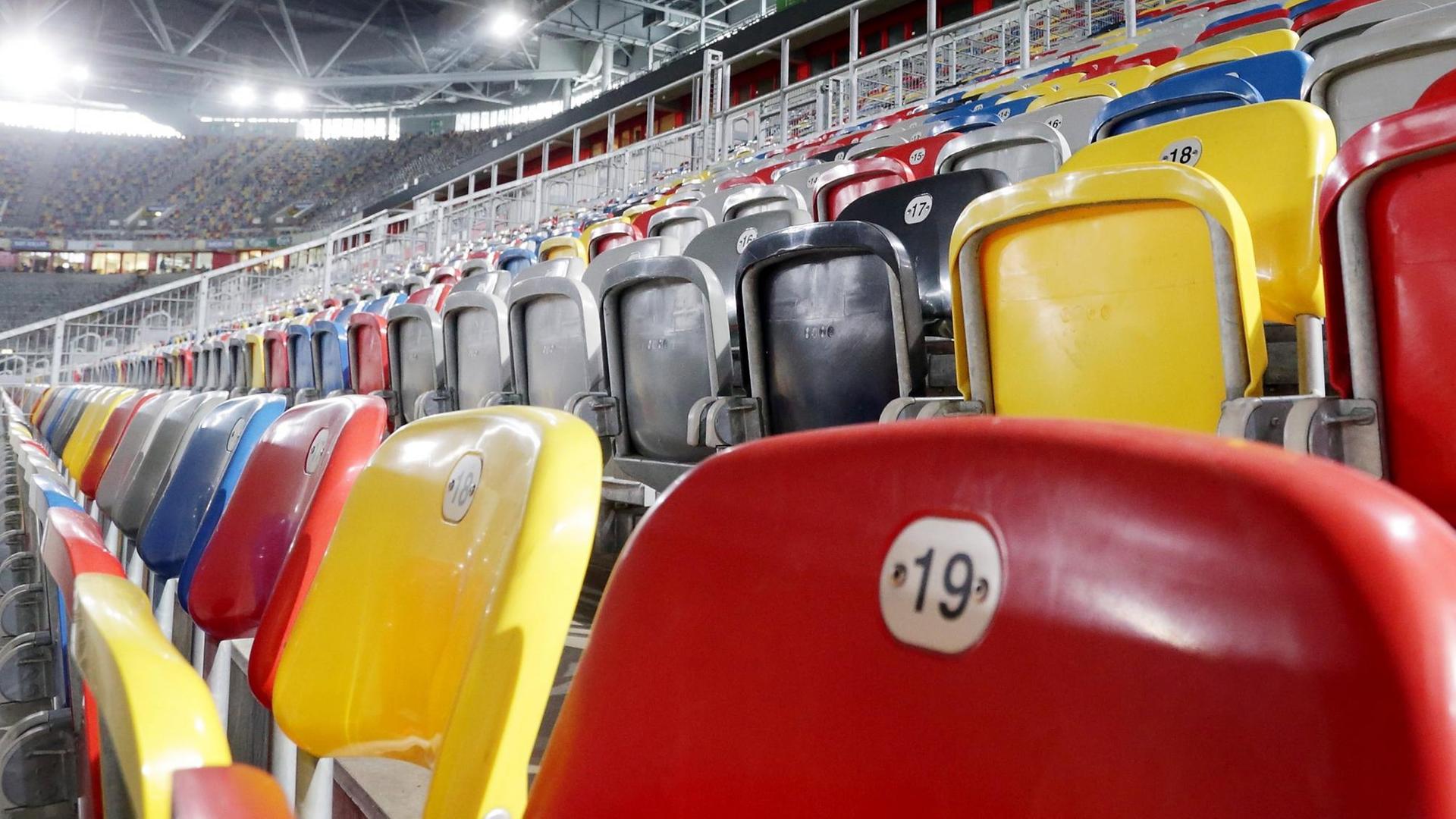 Farbige Sitz-Schalen in einem Stadion. 