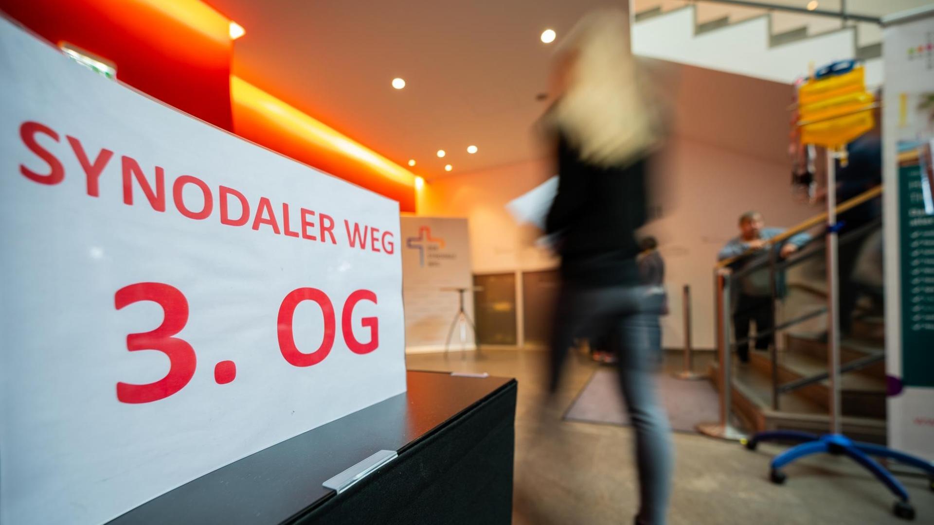 Eine Frau geht zur Veranstaltung "Synodaler Weg" im Haus am Dom. Eine Frau geht zur Veranstaltung "Synodaler Weg" im Haus am Dom.