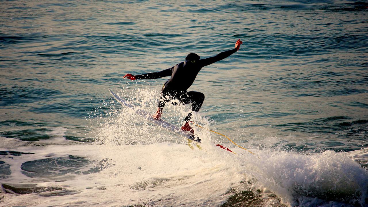 Ein Surfer auf seinem Brett in den Wellen vor Biarritz in Frankreich