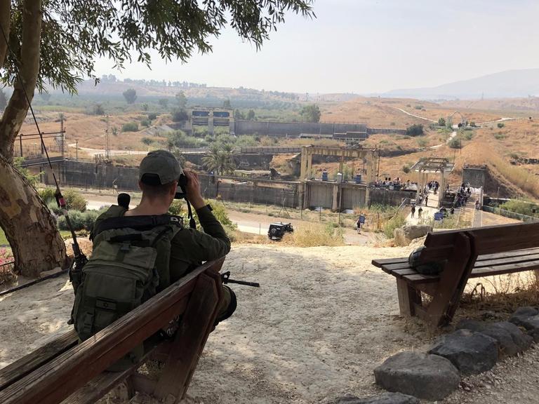 Ein israelischer Soldat sitzt an der Grenze blickt in Richtung Jordanien
