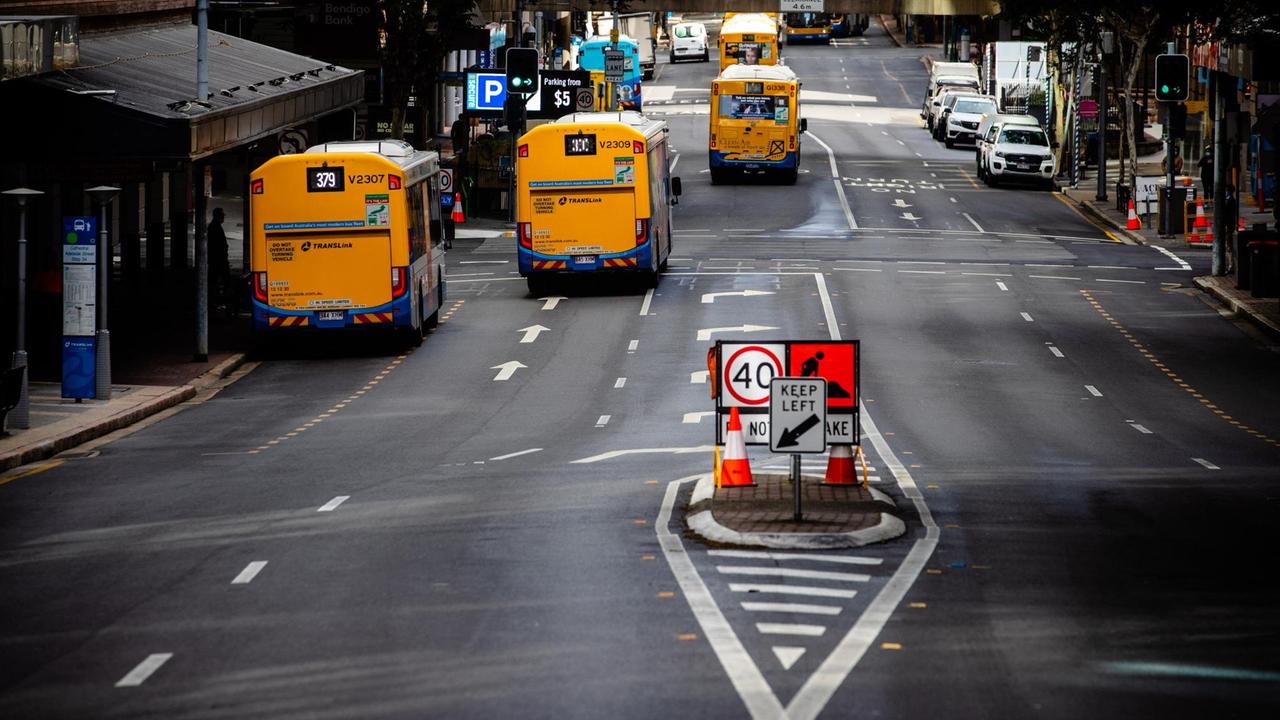 Mehrere gelbe Busse fahren auf einer ansonsten weitgehend leeren Straße Mehrere gelbe Busse fahren auf einer ansonsten weitgehend leeren Straße