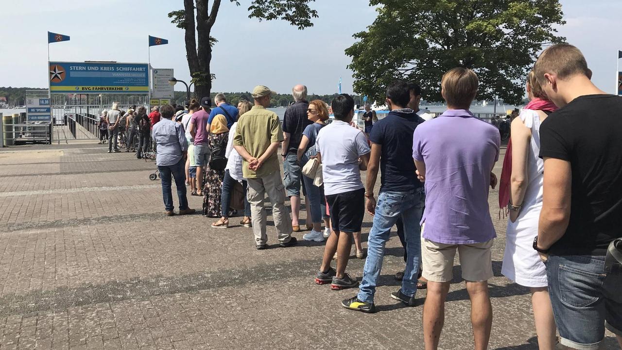 Viele Menschen in legerer Freitzeitkleidung stehen ordentlich in einer Schlange. Viele Menschen in legerer Freitzeitkleidung stehen ordentlich in einer Schlange.