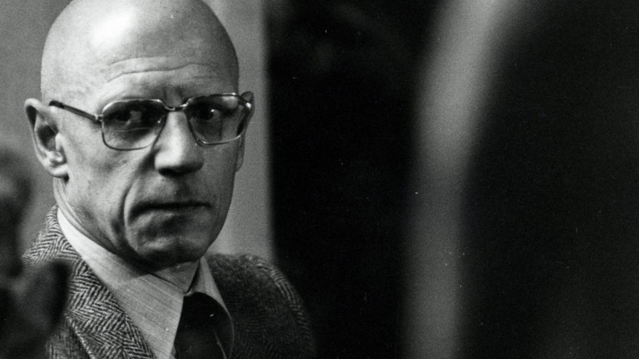 Der französische Philosoph Michel Foucault schaut aus den Augenwinkel an der Kamera vorbei. Er trägt eine große Brille. Der französische Philosoph Michel Foucault schaut aus den Augenwinkel an der Kamera vorbei. Er trägt eine große Brille.