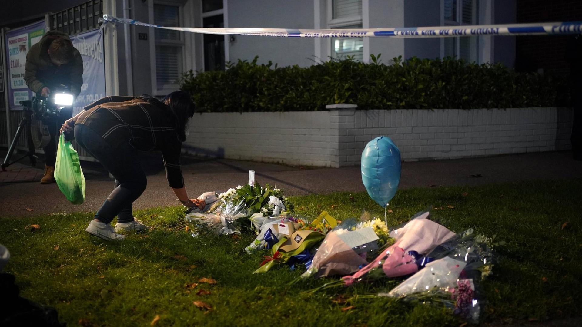 Eine Frau legt einen Blumenstrauss zum Gedenken an David Amess vor die Belfairs Methodist Church in Essex, UK. 15. Oktober 2021. Eine Frau legt einen Blumenstrauss zum Gedenken an David Amess vor die Belfairs Methodist Church in Essex, UK. 15. Oktober 2021.