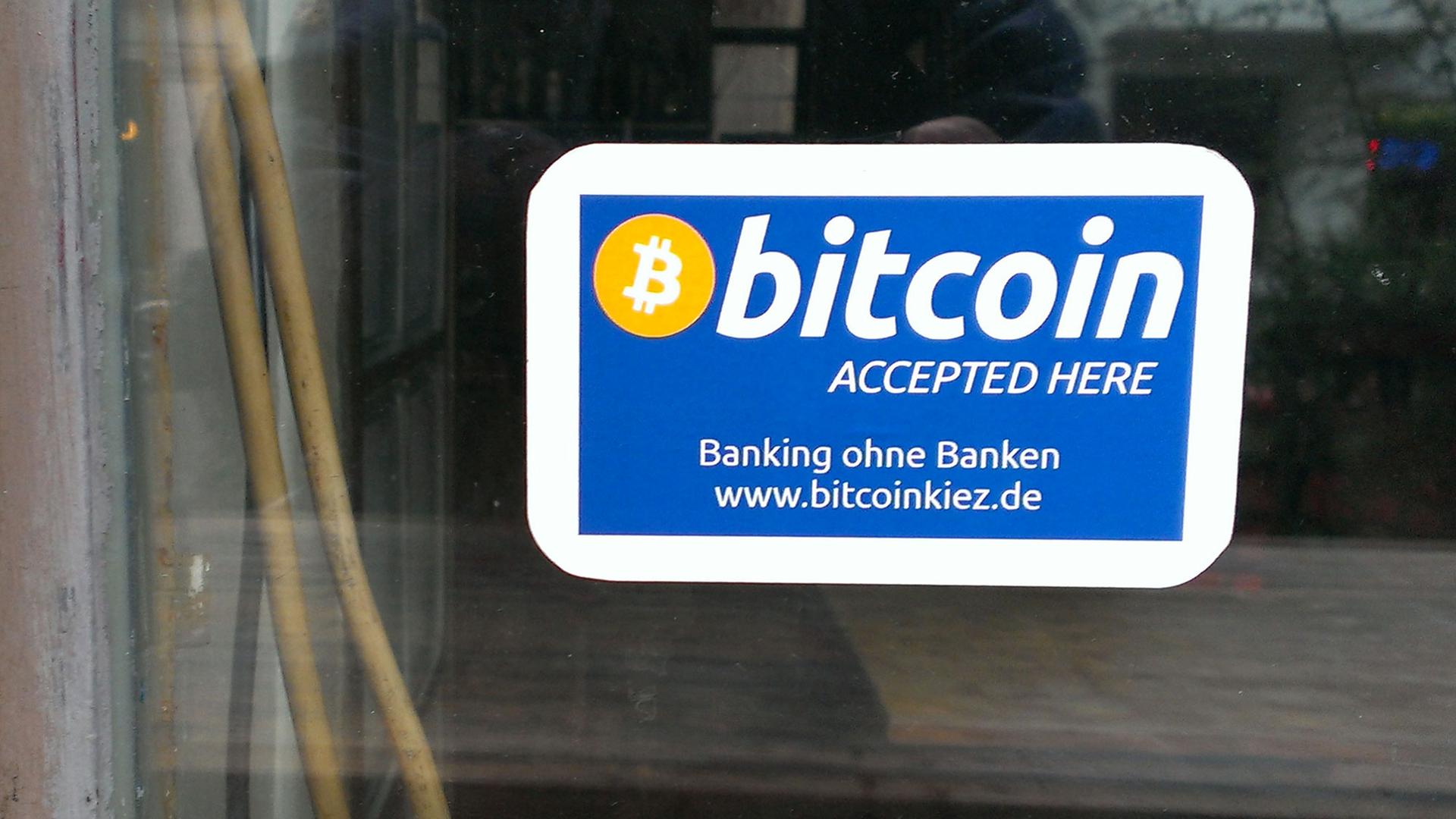 Bitcoins-Aufkleber auf einer Glasscheibe Bitcoins-Aufkleber auf einer Glasscheibe