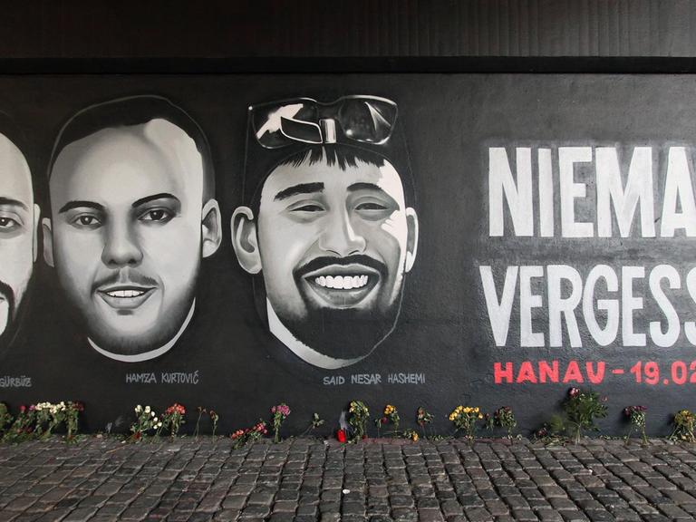 Ein Wandgemälde mit dem Schriftzug „Niemals Vergessen - Hanau 19.02.2020“ und den Porträts der Mordopfer des Anschlags, hier ein Ausschnitt aus dem Gemälde in Frankfurt am Main.