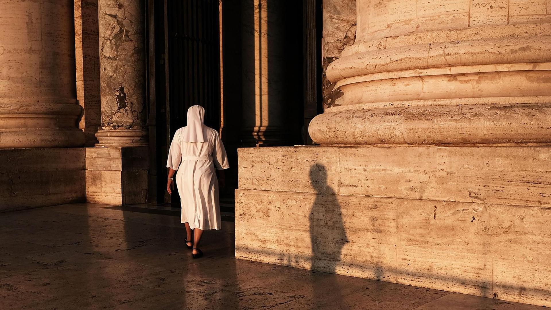 Eine Nonne betritt die St. Peter's Basilica im Vatikan in Rom in der Dämmerung. Eine Nonne betritt die St. Peter's Basilica im Vatikan in Rom in der Dämmerung.