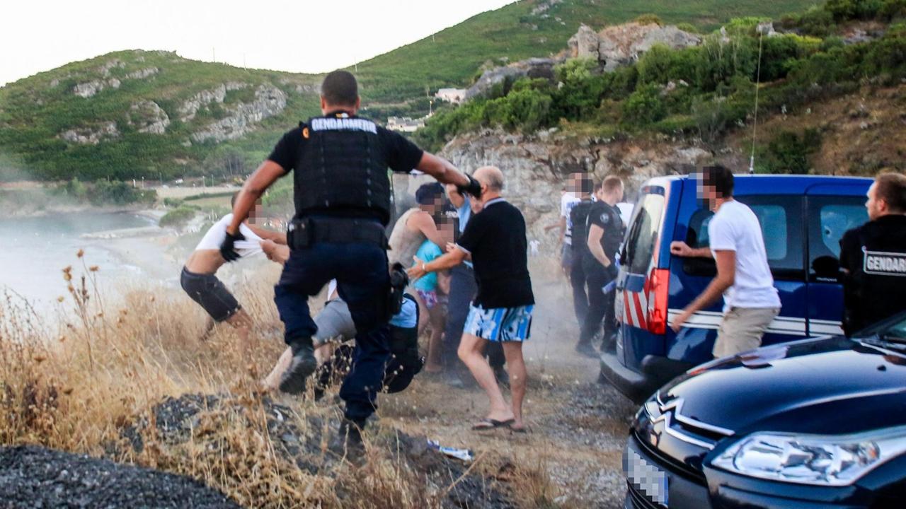 Die Polizei versucht, eine Gruppe sich prügelnder Männer zu trennen. Die Polizei versucht, eine Gruppe sich prügelnder Männer zu trennen.