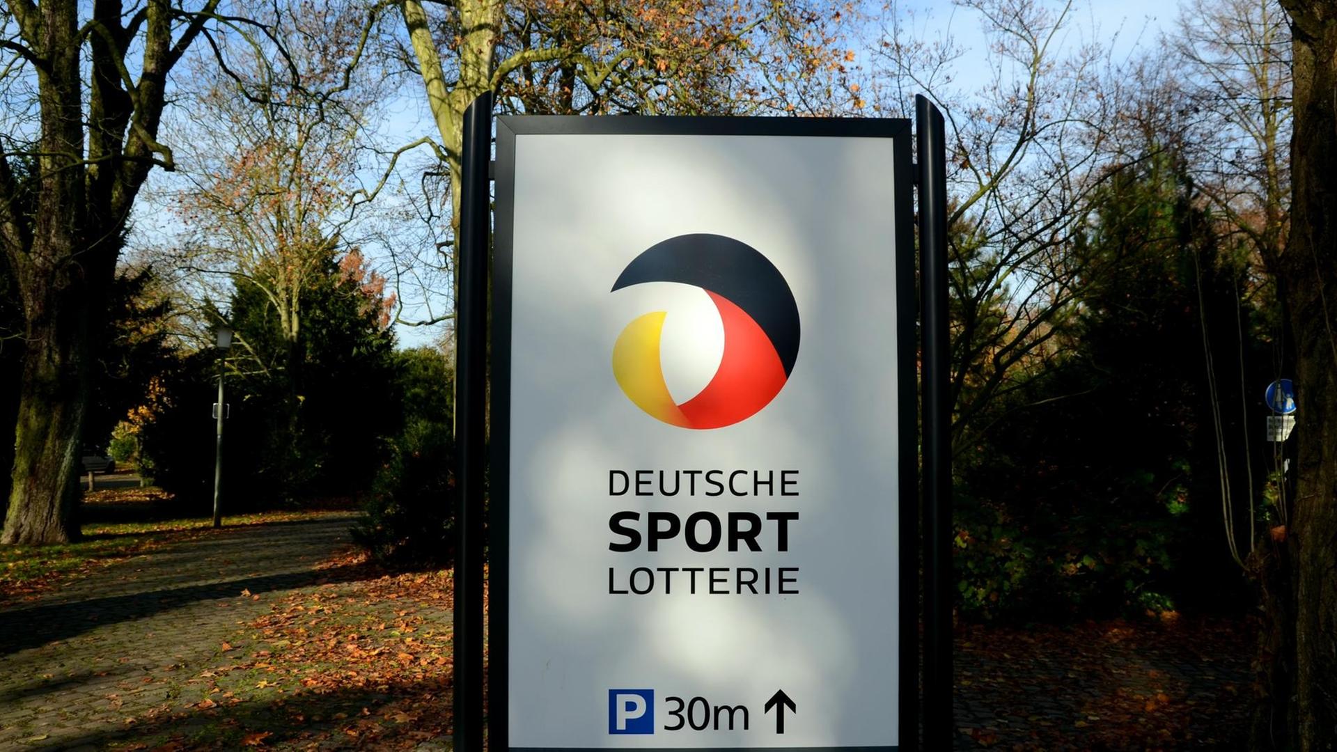 Ein Hinweisschild mit dem Logo "Deutsche Sport - Lotterie" steht an einem Weg im Schönhausenpark in Krefeld (Nordrhein-Westfalen). Ein Hinweisschild mit dem Logo "Deutsche Sport - Lotterie" steht an einem Weg im Schönhausenpark in Krefeld (Nordrhein-Westfalen).