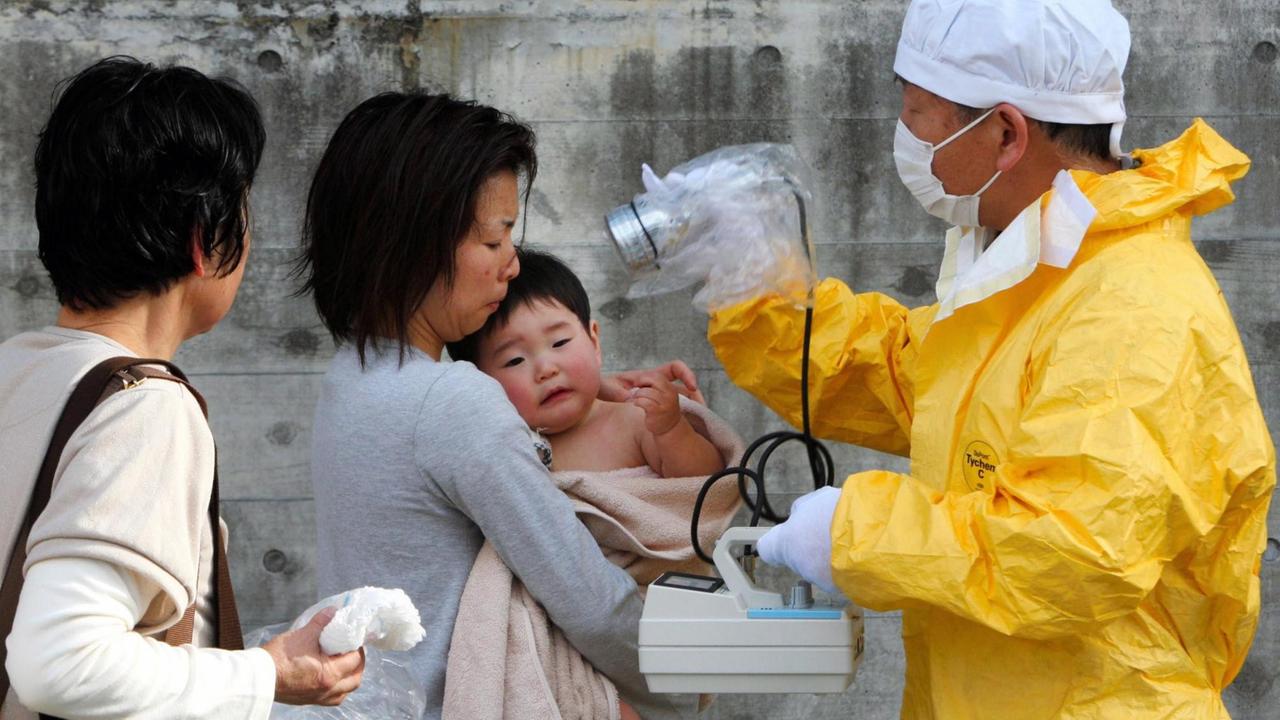 Eine Mutter und ihr Kind werden nach dem Atomunfall von Fukushima im März 2011 auf radioaktive Bestrahlung untersucht. Eine Mutter und ihr Kind werden nach dem Atomunfall von Fukushima im März 2011 auf radioaktive Bestrahlung untersucht.