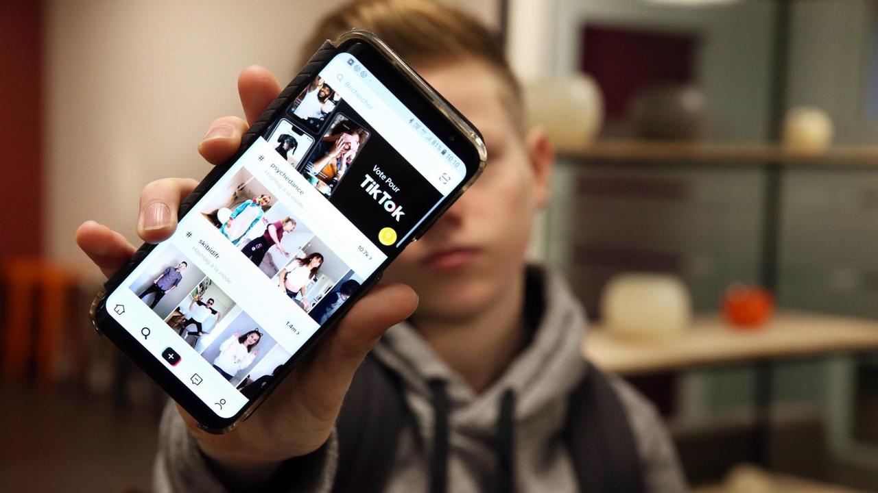 Ein Junge hält sein Smartphone in die Kamera, auf dem die App TikTok ge...</p>

                        <a href=