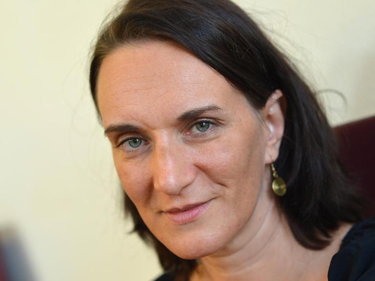 Die Autorin Terezia Mora blickt am Rande der Verleihung des Deutschen Buchpreises 2013 in die Kamera. Sie hat ein schwarzes Shirt an und schulterlange braune Haare. Sie trägt einen goldenen oder messingsfarbenen Ohrhänger.